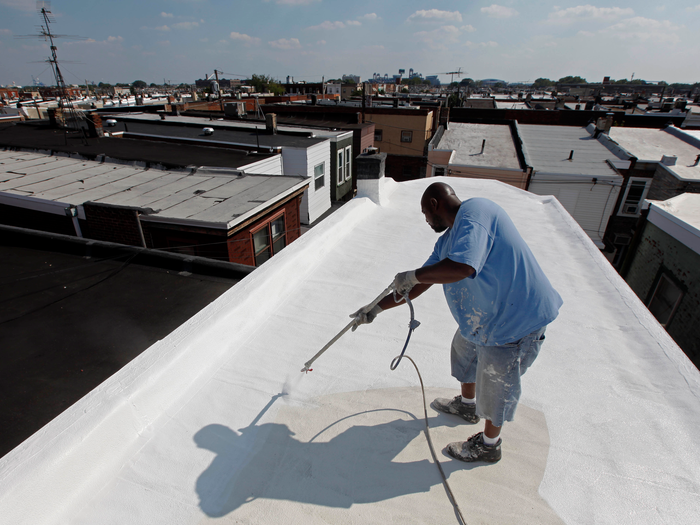 Man painting roof white